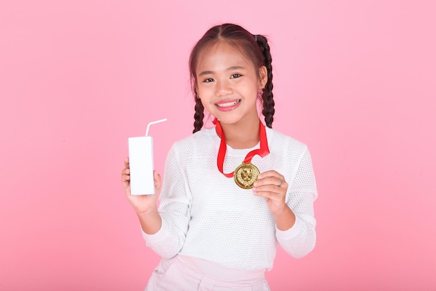 Horizontal portrait of a cute beautiful Asian little kid girl holding milk box isolated on background