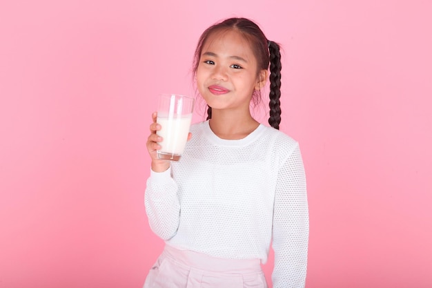 Horizontal portrait of a cute beautiful Asian little kid girl holding milk box isolated on background