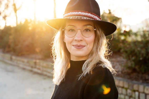 Horizontal portrait of happy woman smiling on the street wearing french trendy glasses.