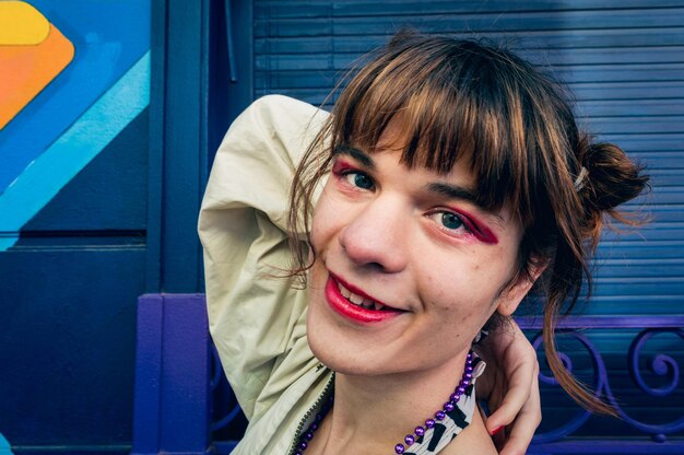 Горизонтальный портрет счастливой молодой трансгендерной латиноамериканки, смотрящей в камеру и улыбающейся копией пространства