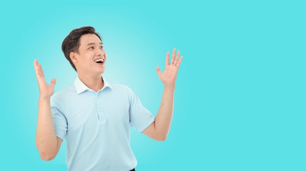 Horizontal portrait image of happy young man in studio over light blue background