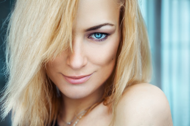 Photo horizontal portrait of sexy young adult blonde girl with blue eyes.