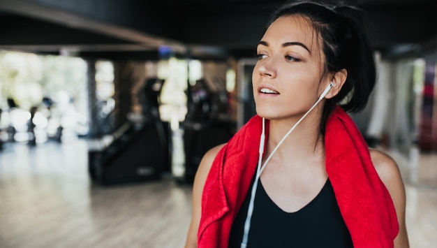 Photo horizontal portrait young caucasian woman runner resting after workout session in the gym female jogger taking a break from running workout people sport and fitness concept