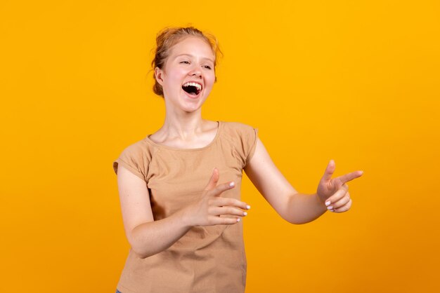 Horizontal portrait of young laughing girl isolated on yellow studio background concept of human