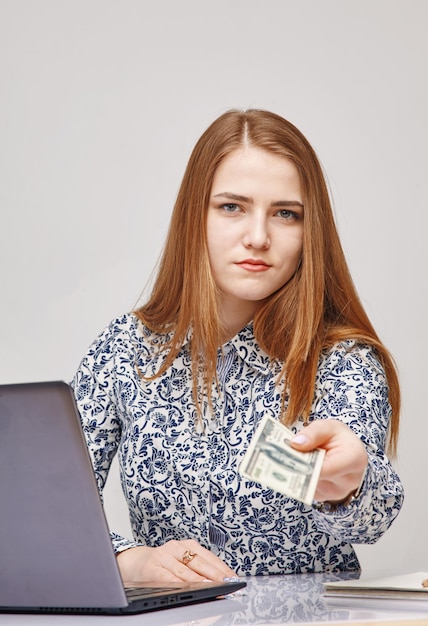 Horizontal portrait of a young woman showing dollar bill