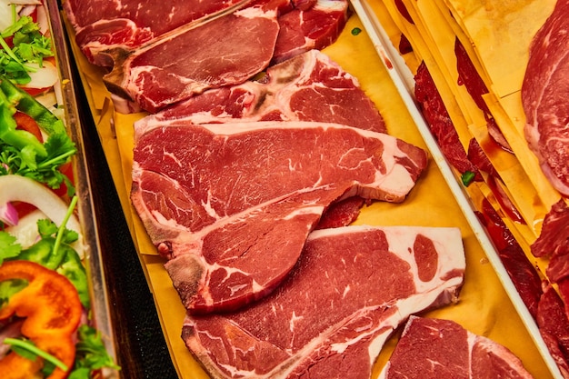 Horizontal row of raw tbone steaks asset