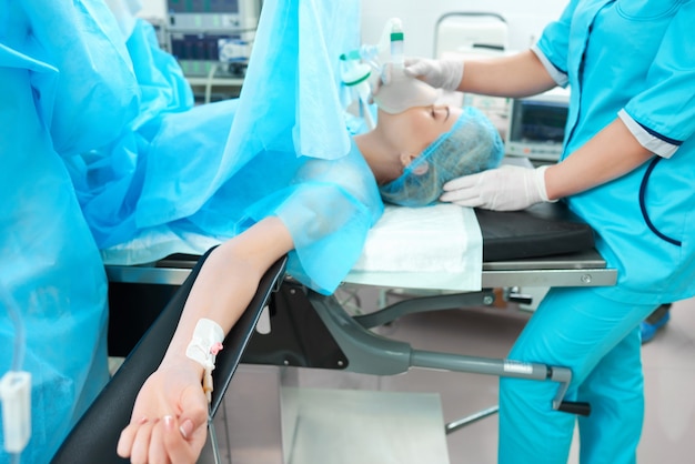 Horizontal shot of a female patient lying on the operating table at the surgery room team of surgeons working at the hospital people vitality medicine healthcare concept.