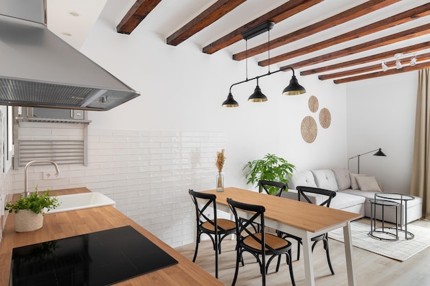 写真 ロフトスタイルのキッチン・リビングルームの水平ショット現代的な木製ビームの白い壁