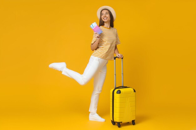 Фото Горизонтальный снимок белой женщины, готовой к поездке с багажем и билетами
