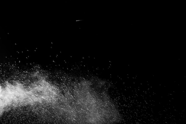 Horizontal steam with drops of spray flying in different directions on a black background for overlay on a photo Stream jet of hot water with steam and drops