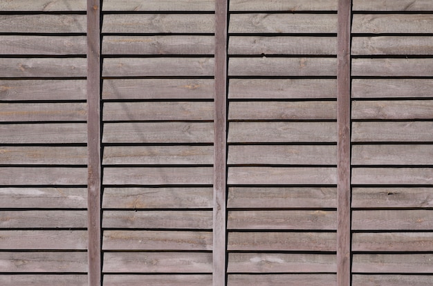 Фото Горизонтальная текстура стены из нескольких рядов коричневых старых деревянных досок. окрашенная деревянная стена в коричневый цвет