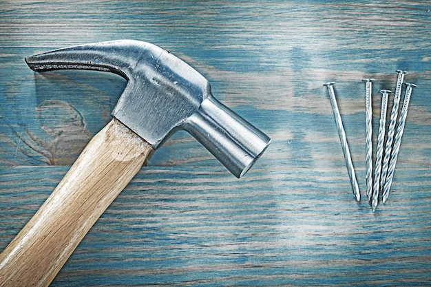 Horizontal view of claw hammer nails on wooden board construction concept