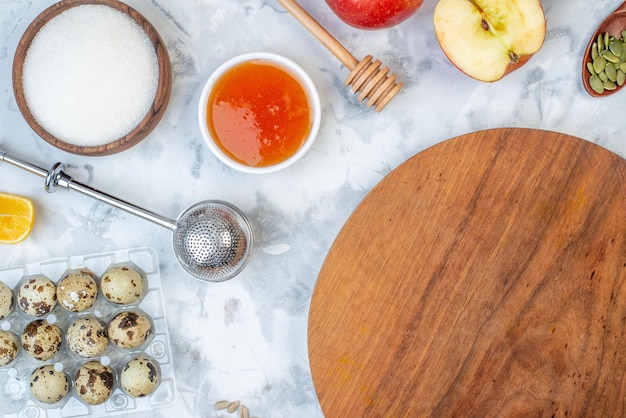 Vista orizzontale della tavola rotonda in legno e degli ingredienti per il cibo sano su sfondo bianco macchiato