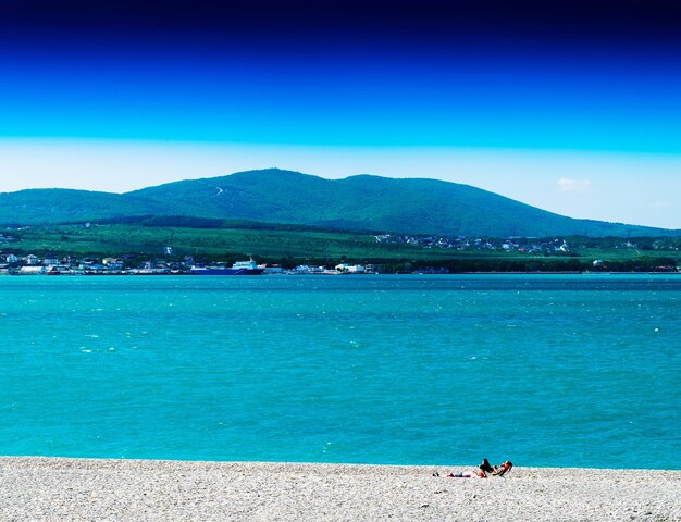 Spiaggia sassosa vivida orizzontale con sfondo di grande paesaggio collinare