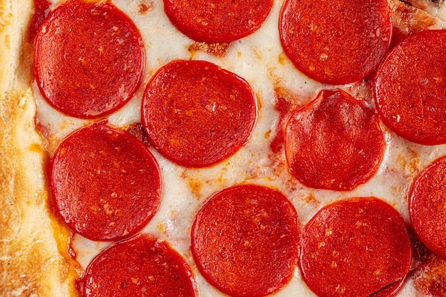 Horizontale close-up op de textuur van de pepperonis en kaaspizza