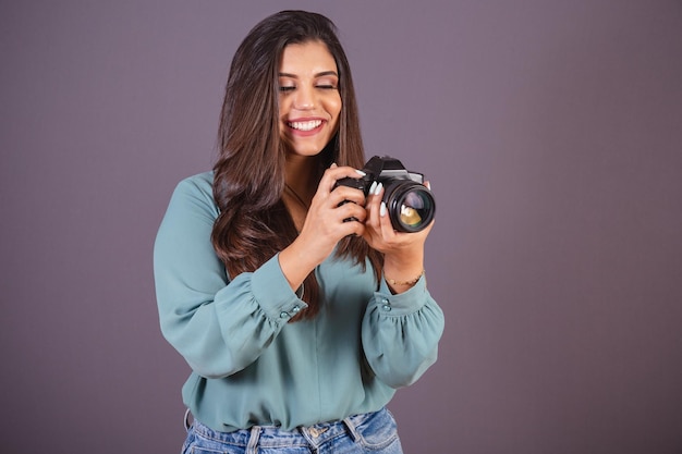 Horizontale foto Mooie Braziliaanse vrouw met vrijetijdskleding Spijkerbroek en groen shirt vrouwelijke fotograaf met fotocamera