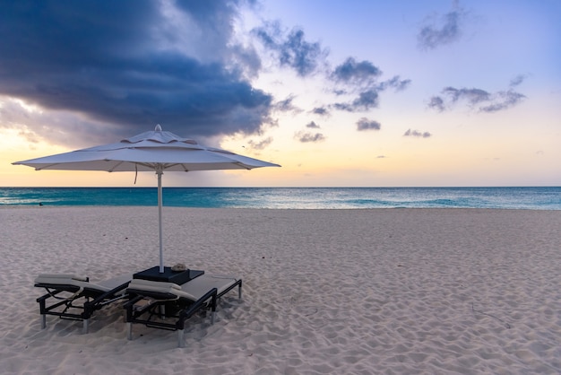 Horizontale opname van het prachtige uitzicht op het strand en de zee, met parasol en stoelen op Aruba