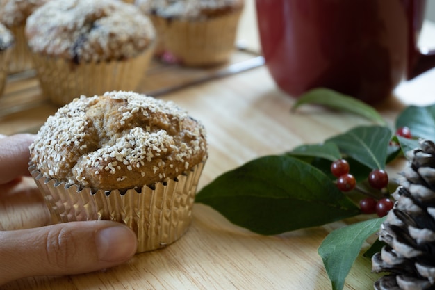 Foto horizontale selectieve focusweergave van de hand met kerstcupcake, met kopieerruimte.