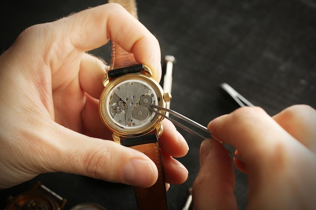 Horlogemakerhanden repareren mechanisme van oude horloge close-up
