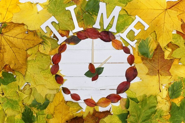 Horloges van bladeren op een witte houten achtergrond