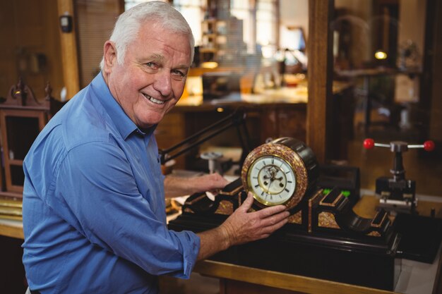 Horologist checking a clock in workshop