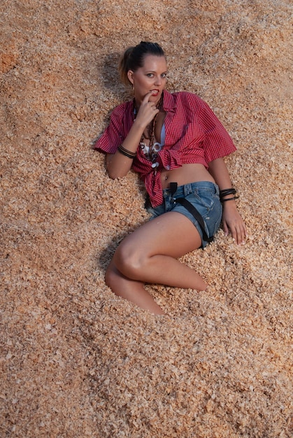 horsegrooming woman lying in the straw of the animals