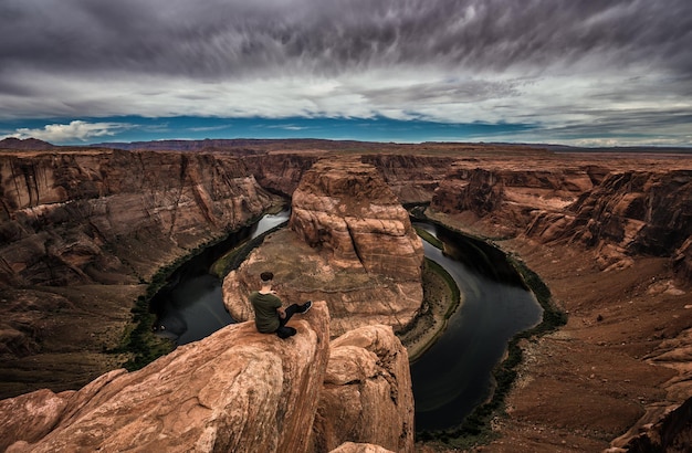 Horseshoe bend and a hiker at the edge