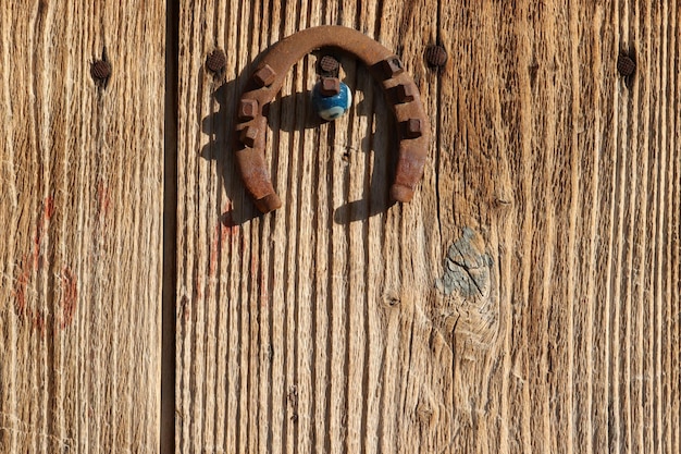 Horseshoe and evil eye bead on old wooden door