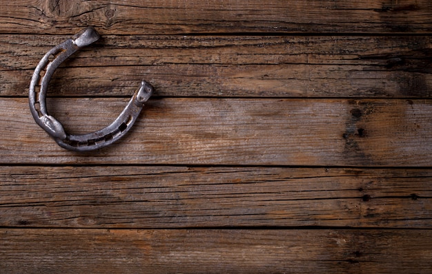 Photo horseshoe metal vintage weathered wooden background.