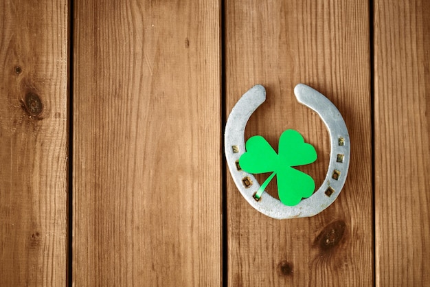 horseshoe with shamrock on wooden background