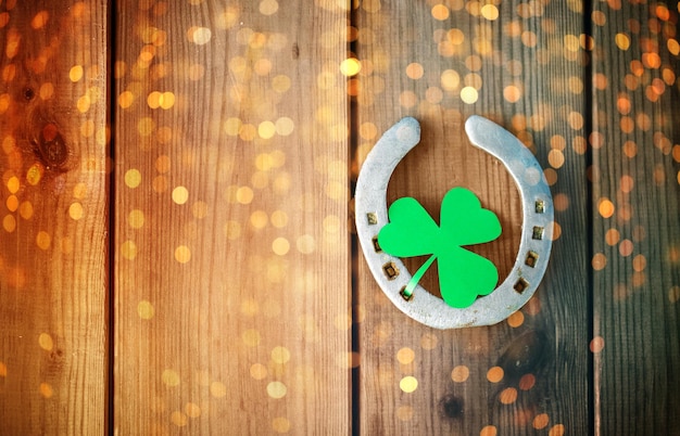 horseshoe with shamrock on wooden background