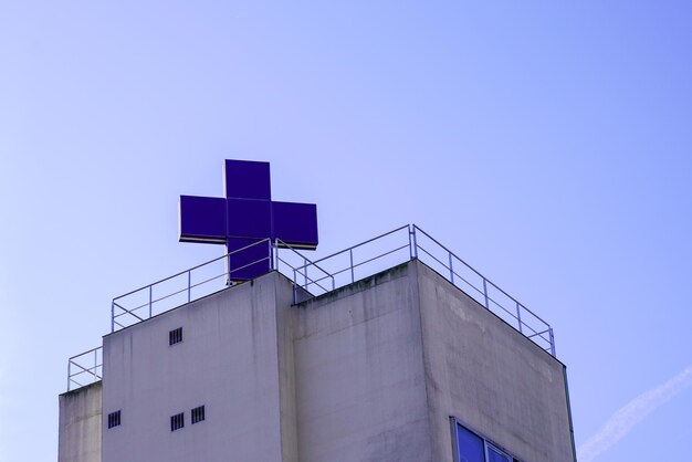 Hospital building facade with big roof blue cross