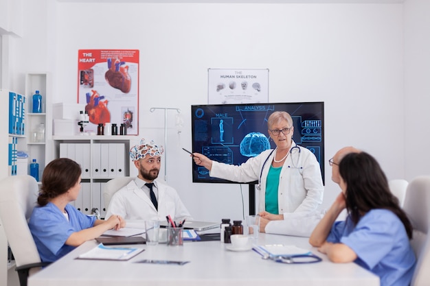 Hospital medical team doing brain activity research using headset with sensors monitoring radiography expertise