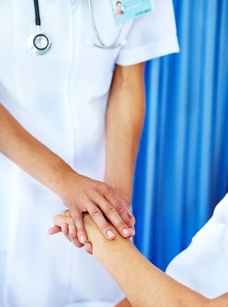 Hospital person and nurse holding hand with support for consultation diagnosis or communication Healthcare help and doctor with patient for sympathy comfort or medical services in clinic