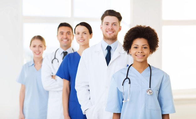 hospital, profession, people and medicine concept - group of happy doctors at hospital