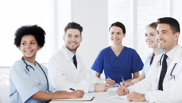 Photo hospital, profession, people and medicine concept - group of happy doctors meeting at medical office