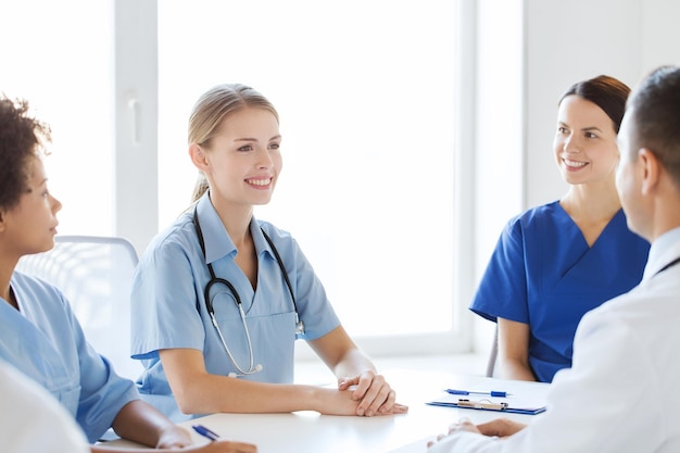 hospital, profession, people and medicine concept - group of happy doctors meeting and talking at medical office