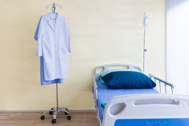 Hospital room with empty bed, infusion set, intravenous fluid and doctor suite.