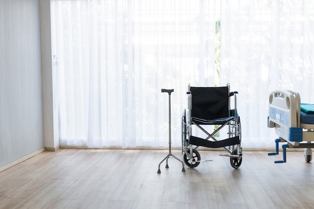 Hospital room with empty bed, infusion set, intravenous fluid and wheelchairs.