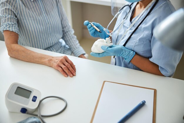 Hospital staff member demonstrating a heart replica to a pensioner