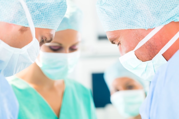 Hospital - surgery team in operating room or Op of a clinic operating on a patient in an emergency situation