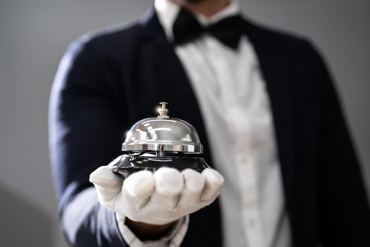 Photo hospitality service concierge in uniforms with butler bell