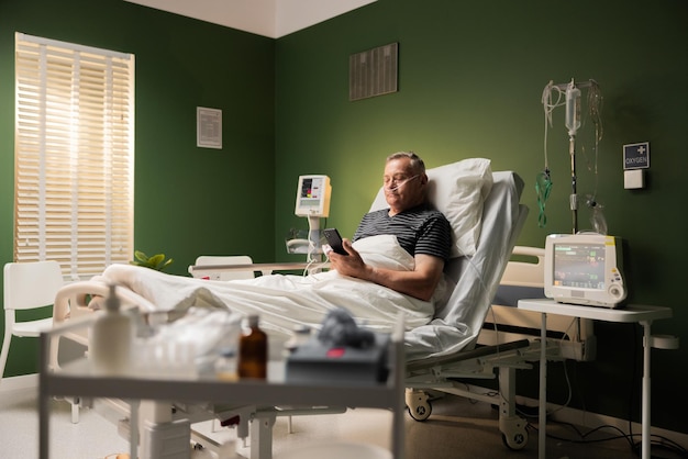 Hospitalized senior holding a cellphone with an oxygen tube and finger monitor