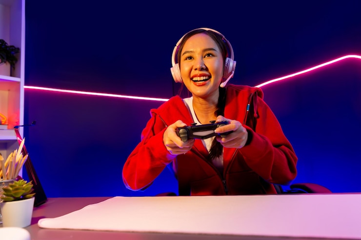 Photo オンラインゲームstratagemをプレイするジョイスティックで笑顔のアジア人チャンネルのホスト