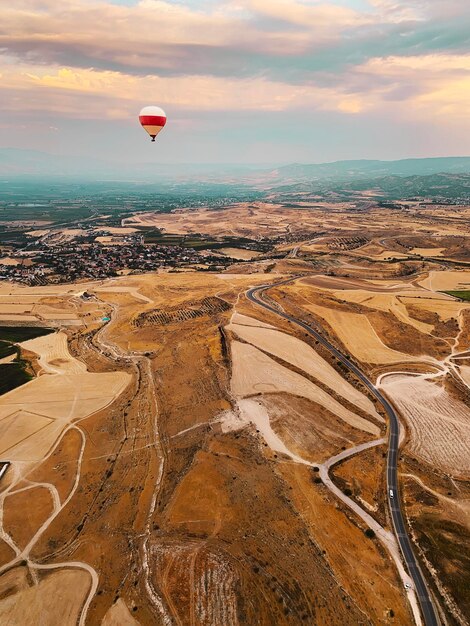 Photo hot air balloon flying over land