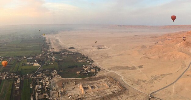 Hot air balloon flying over landscape against sky