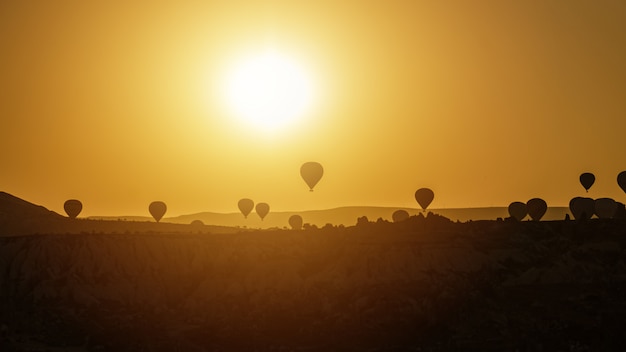 Hot air balloon flying over rock landscape at Cappadocia Turkey