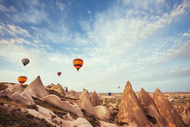 Hot air balloon flying over rock landscape at Cappadocia Turkey.