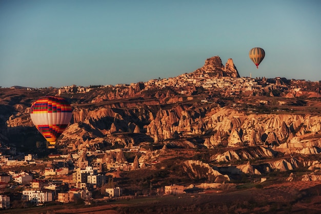 카파도키아 터키에서 바위 풍경을 통해 뜨거운 공기 풍선 비행.