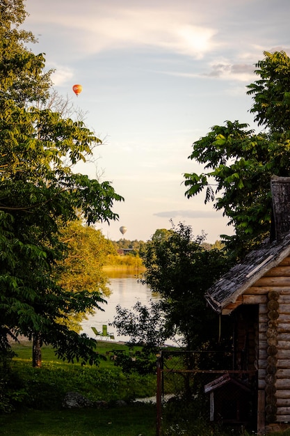 a hot air balloon is flying over a cabin.